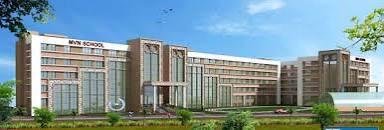 Top schools in faridabad Modern school building with glass facade and landscaped surroundings under a clear blue sky